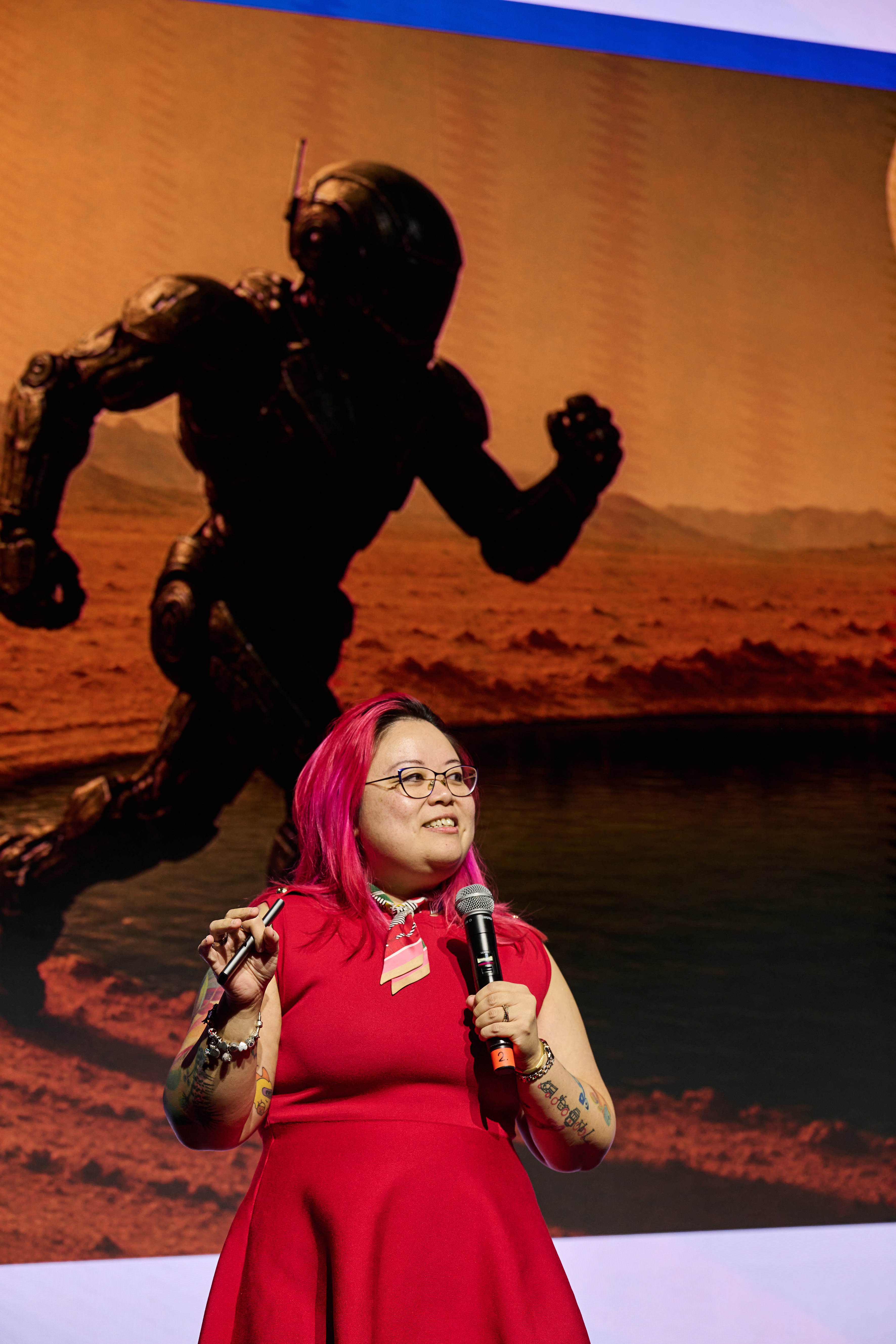 Me looking up at a slide of an armoured robot running across the surface of Mars while I present.