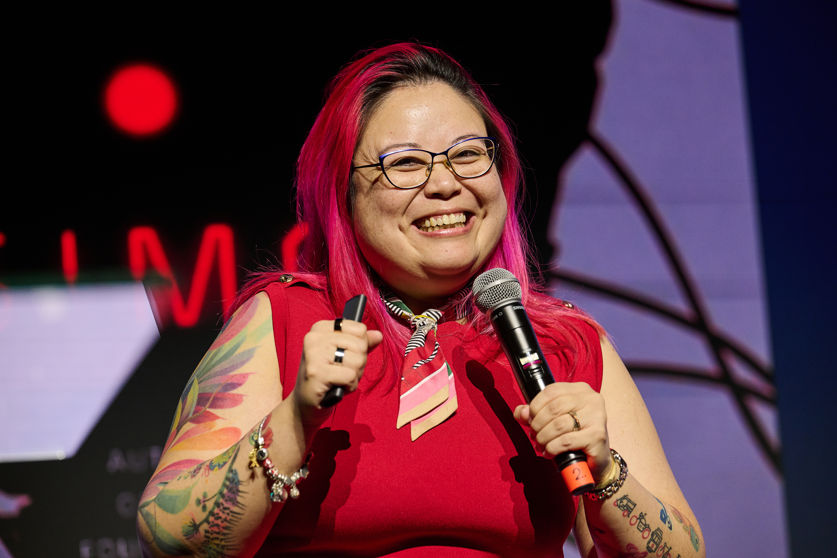 Me grinning during the talk, holding a microphone and presenter clicker.